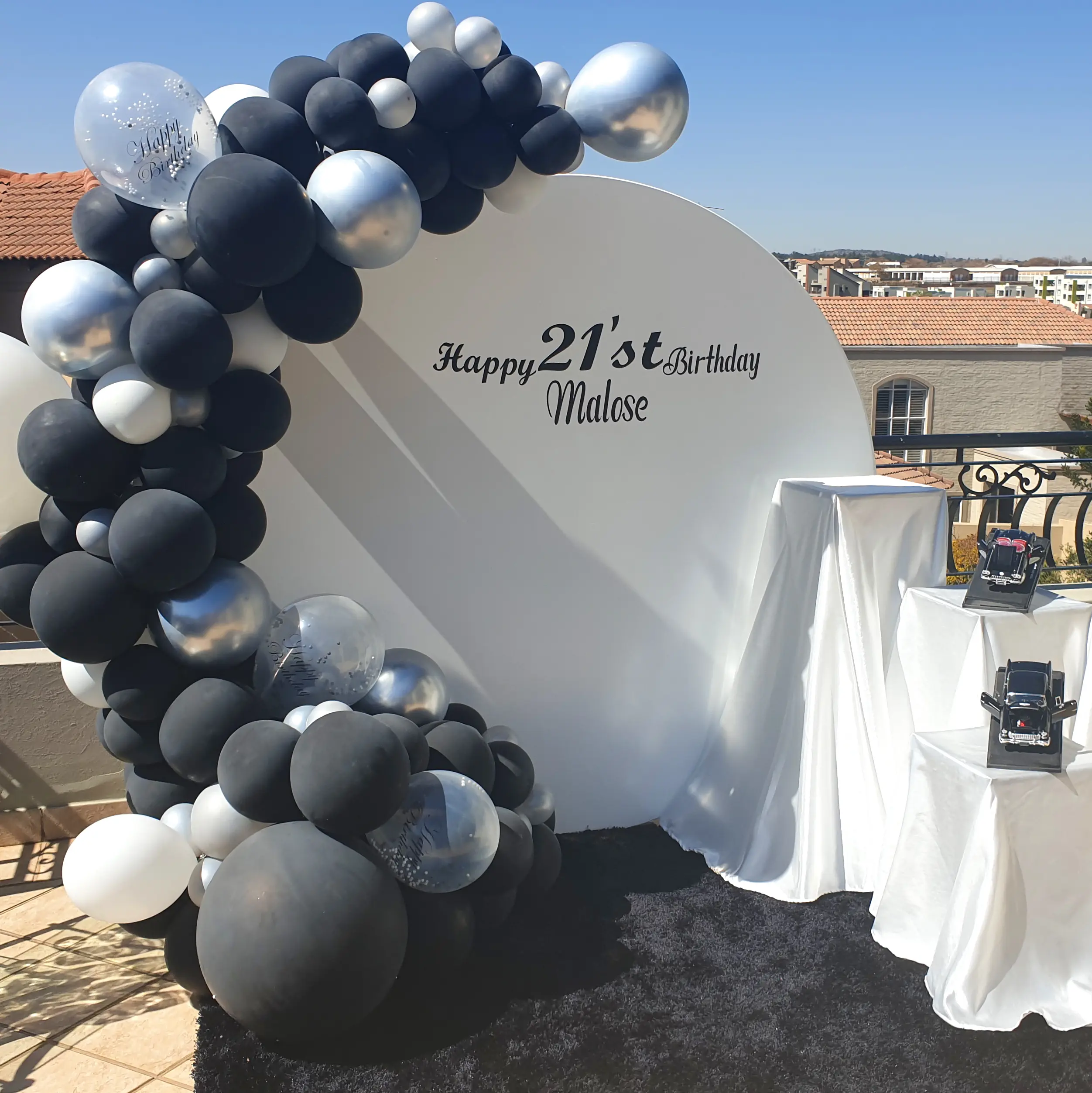 Black and silver balloon arch for a 21st birthday backdrop