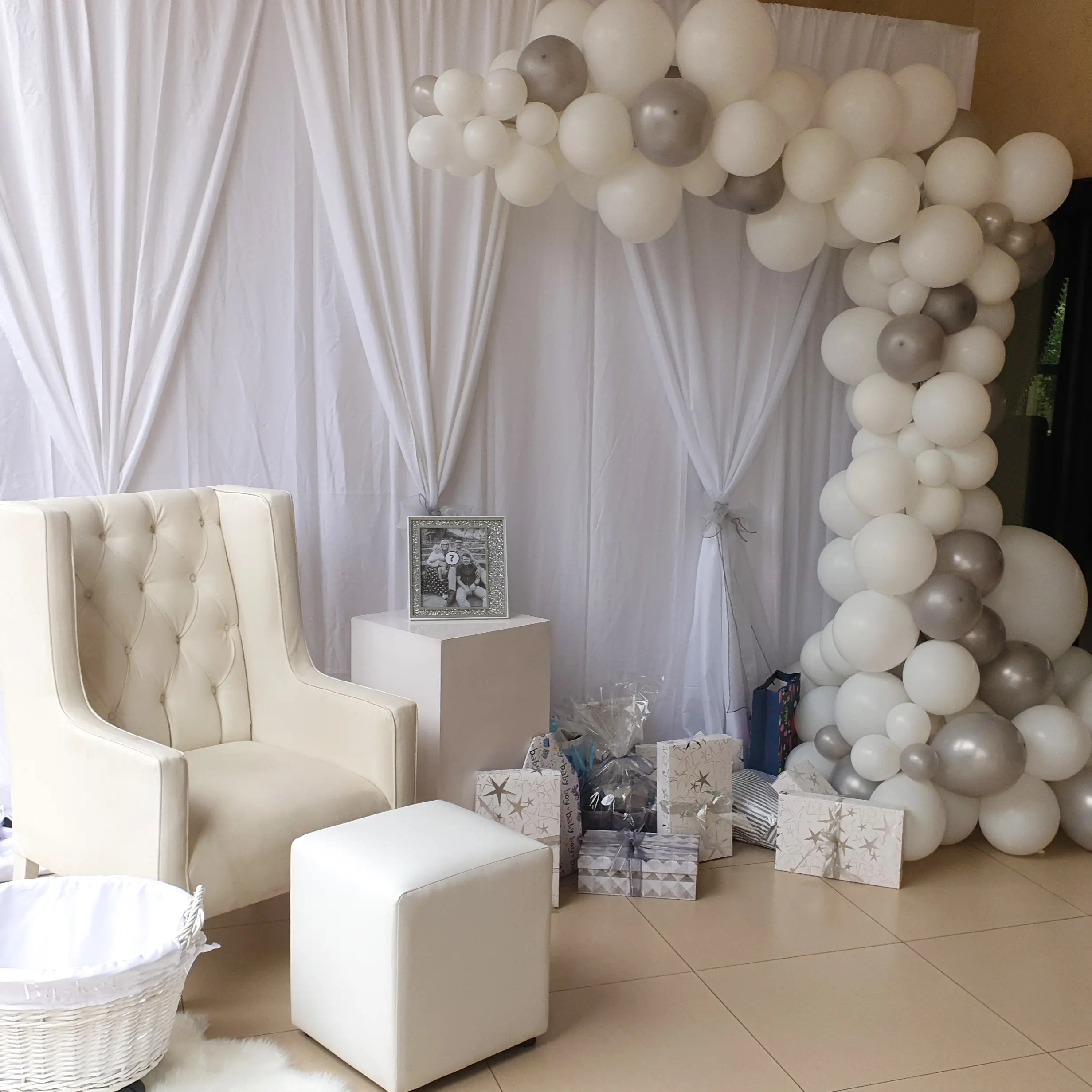 White and silver balloon garland with draped party backdrop