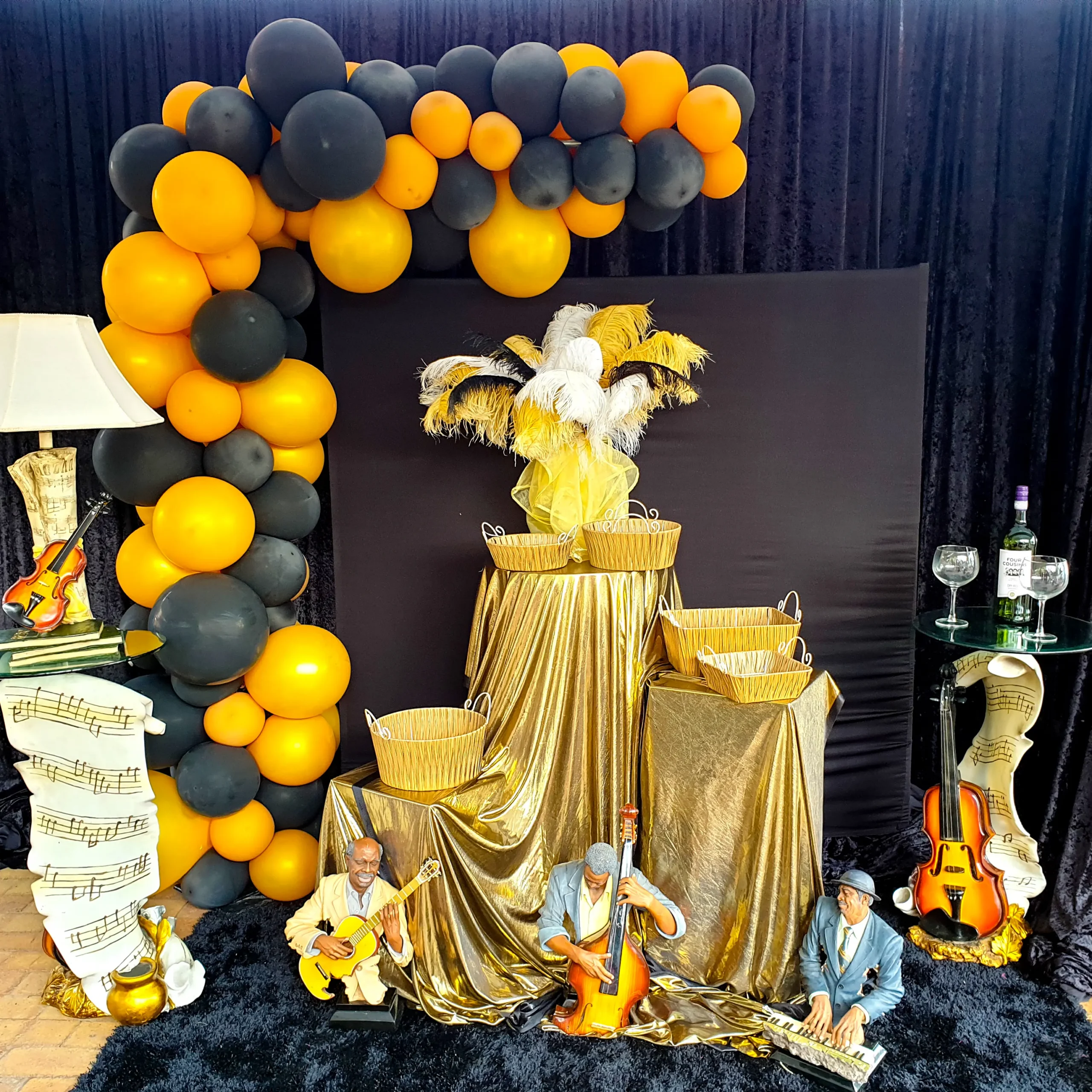 Black and gold jazz-themed balloon arch and décor