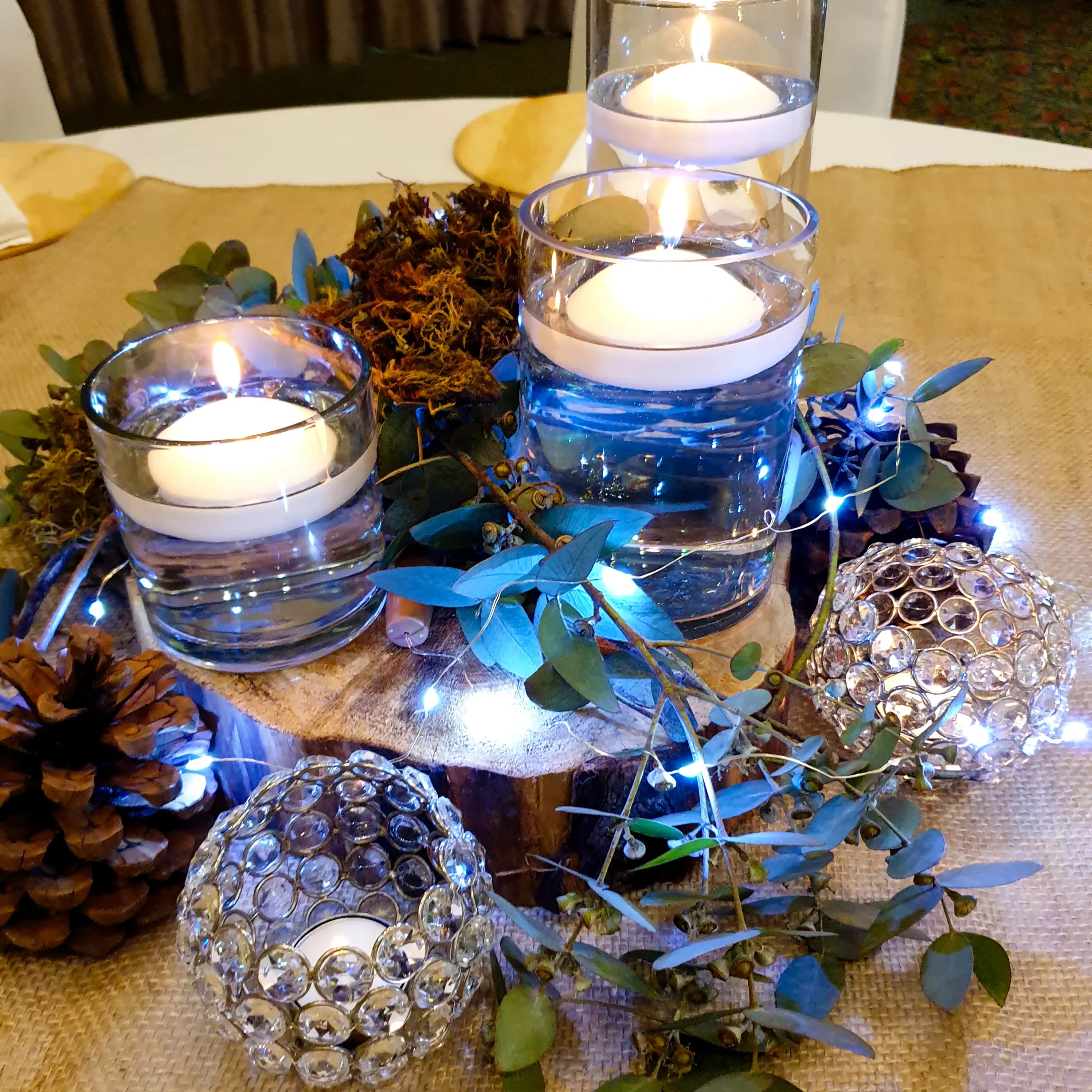 Floating candle and greenery table centrepiece with fairy lights