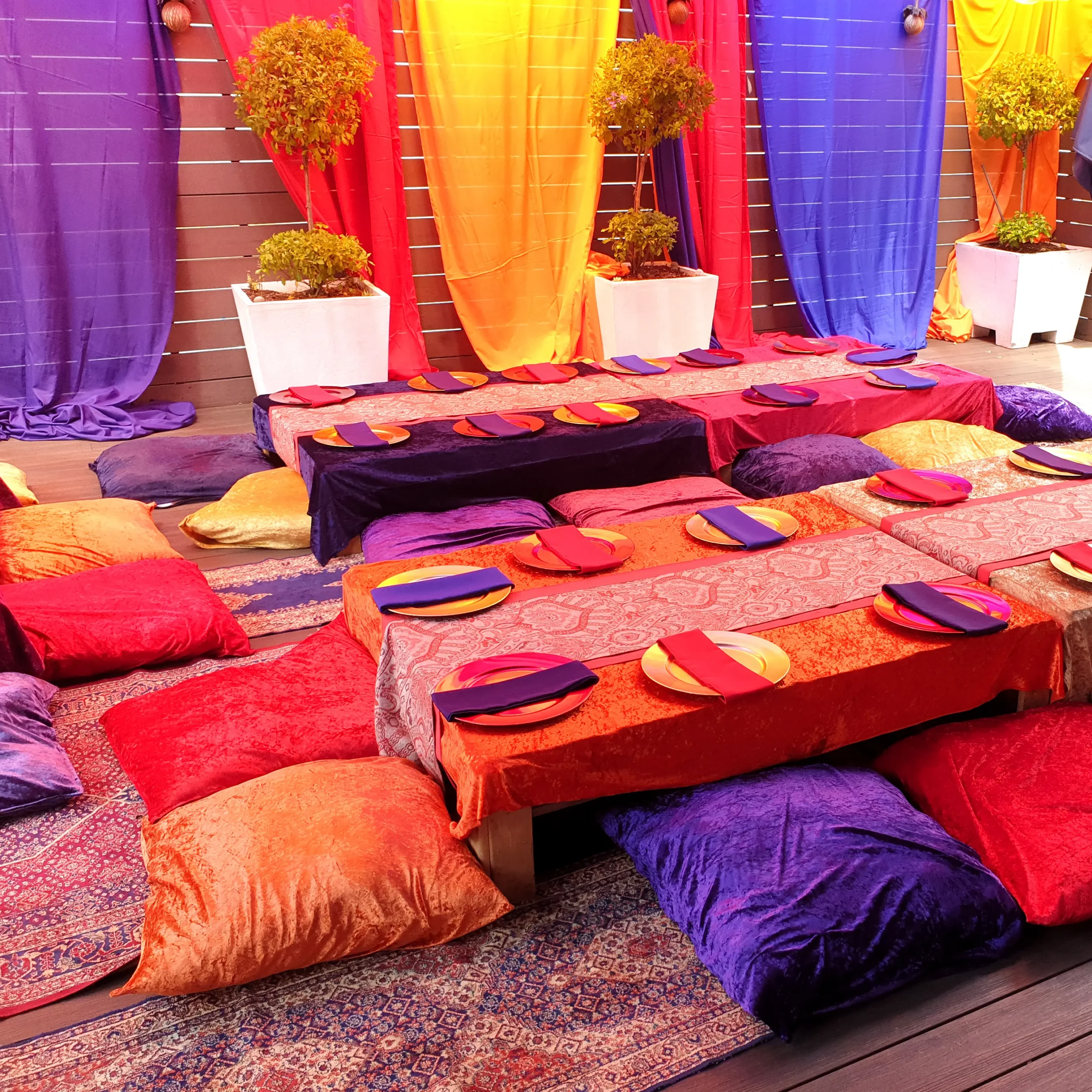 Colourful Arabian nights floor-table party setup with cushions and draping