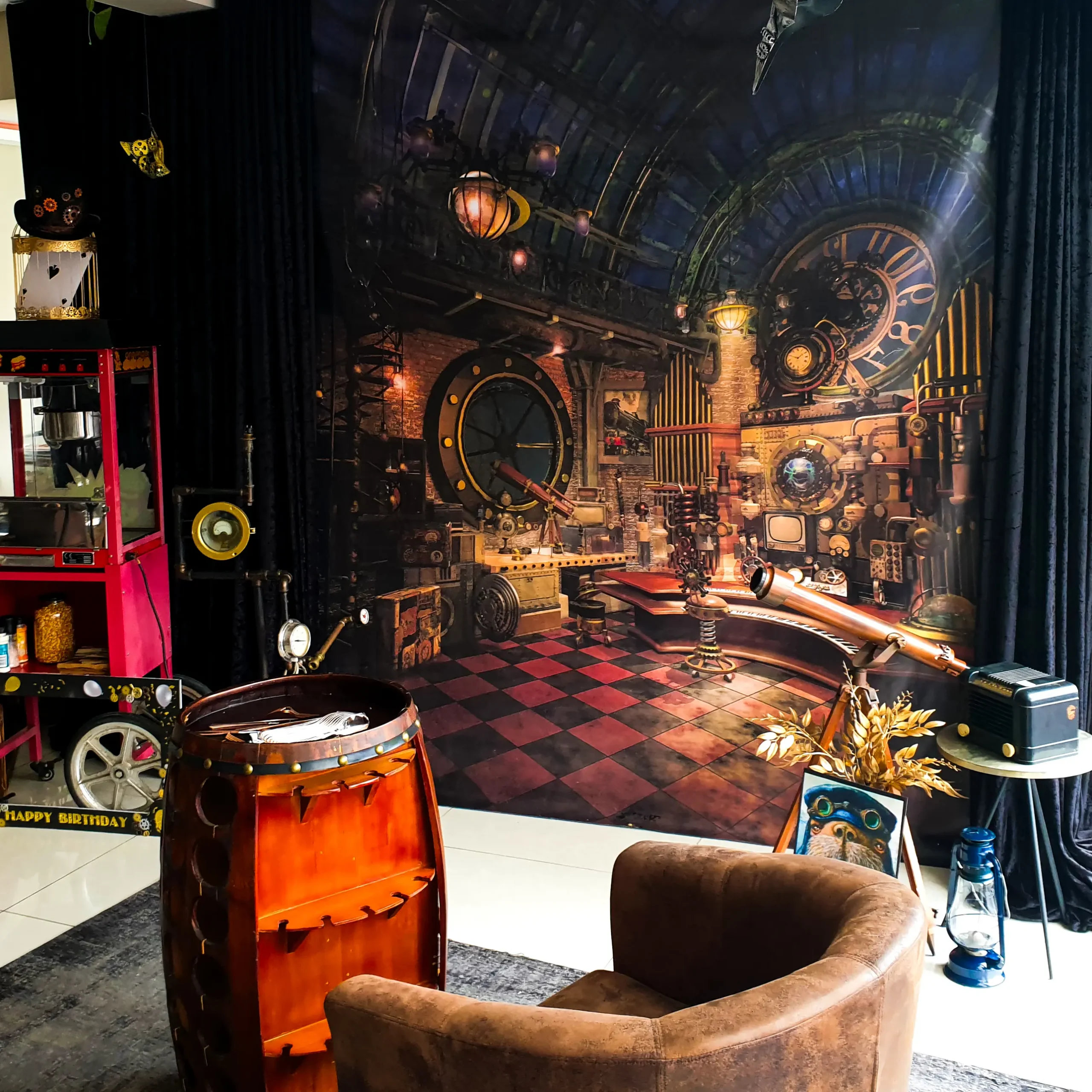 Steampunk-themed event backdrop with vintage props and popcorn machine