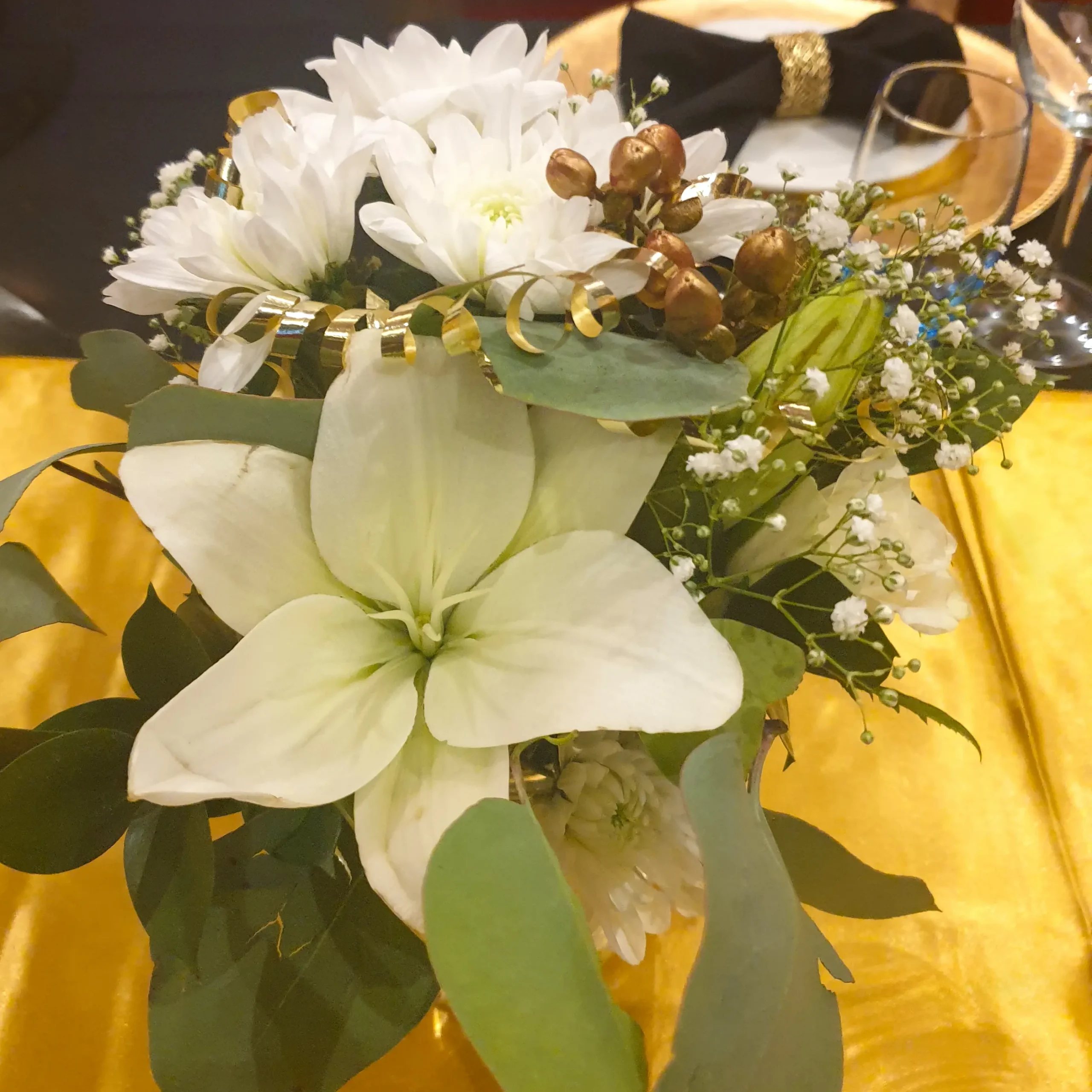 White floral table centrepiece with gold accents