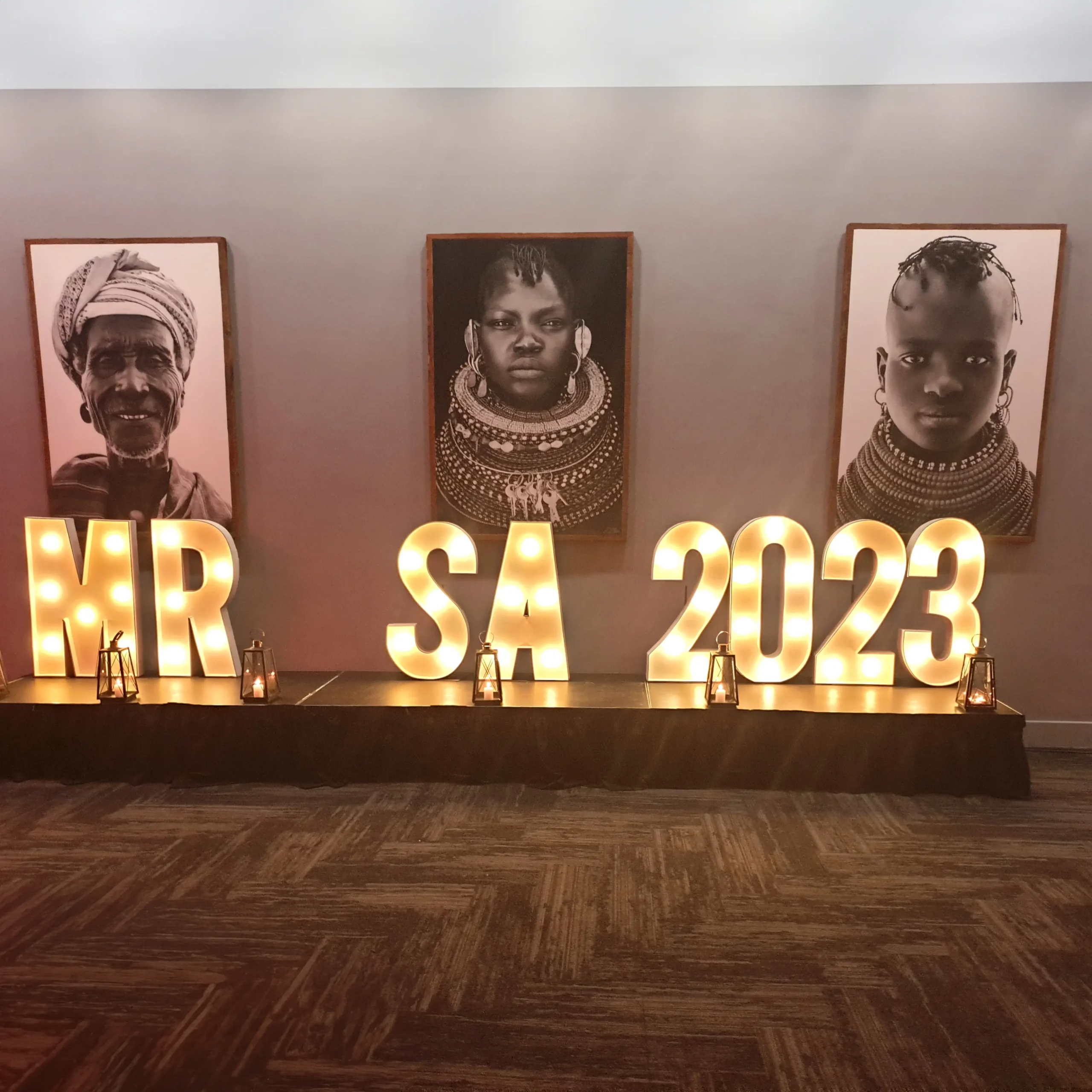 Illuminated MR SA 2023 event letters beneath portrait artwork