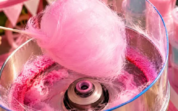 Candyfloss being spun onto a stick in the candyfloss machine
